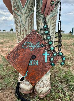 a person wearing cowboy boots and holding a rosary with the word faith written on it