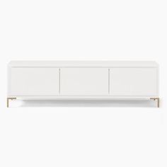 a white sideboard with three doors and two drawers on the bottom, in front of a