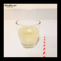 there is a glass of water next to a red and white striped straw