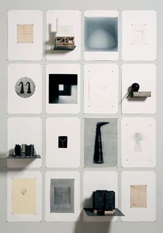 a white wall with many different pieces of art on it's sides and shelves