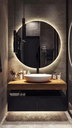 a bathroom with a round mirror above the sink and a wooden counter in front of it