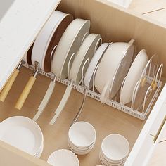 an open drawer filled with white dishes and plates