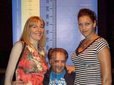 three people standing next to each other in front of a ruler