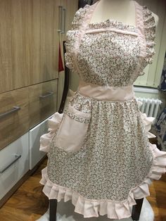 a dress on display in a room with wooden floors and cabinets behind the mannequin