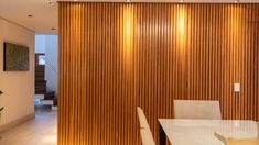 a dining room with wooden walls and white chairs