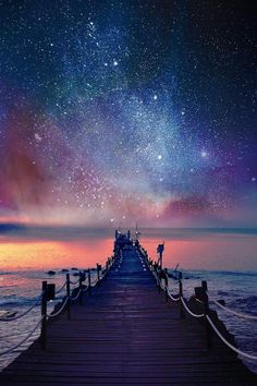 a pier with stars in the night sky