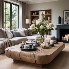 a living room filled with furniture and a fire place in front of a large window