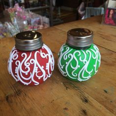 two colorful salt and pepper shakers sitting on top of a wooden table