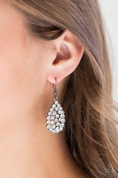 a close up of a woman's ear wearing earrings with white stones on them