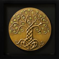 an intricately designed gold plate with a tree in the center and leaves on it