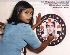 a woman is pointing at a clock with a man's face on it