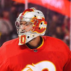 a close up of a hockey player wearing a helmet and looking off to the side