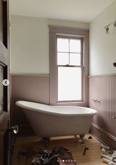 a bathroom with a claw foot bathtub and tools on the floor next to it