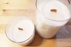 two glasses filled with milk sitting on top of a wooden table