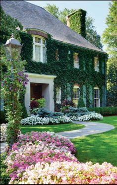 a house with lots of flowers in front of it