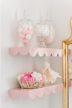 two shelves with pink and white items on them