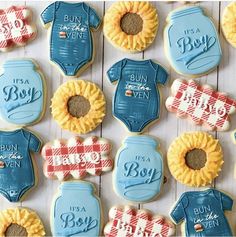 decorated cookies with baby ones and sunflowers are arranged on a white wooden surface