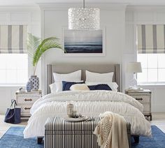 a bedroom with white walls and blue rugs on top of the carpeted floor