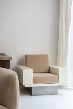 a chair sitting next to a window in a room with white walls and flooring