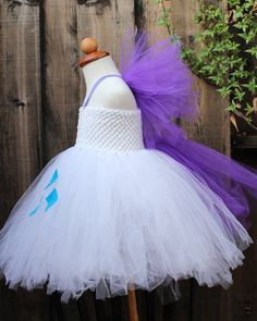 a white and purple tutule dress sitting on top of a mannequin