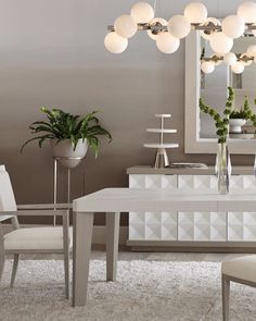 a modern dining room with white furniture and plants