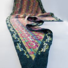 a multicolored scarf laying on top of a white table