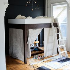 a bunk bed with curtains on it and a ladder to the top that is open