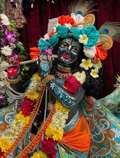 the statue is decorated with flowers and feathers