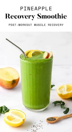 a green smoothie in a glass with lemons and spinach on the side