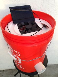 a red bucket with a solar panel in it