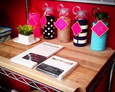 a wooden table topped with books and vases filled with plants next to each other