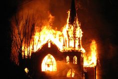 a church on fire burning in the night