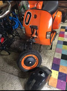 an orange scooter sitting on top of a carpet