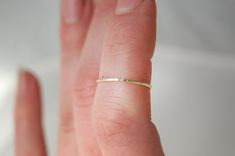 "One simple, super skinny solid gold stacking ring in your choice of 14k, 18k, or 22k gold. Stackable rings are so fun! The ring pictured has been created with the \"Lined\" texture. Please choose from: *Hammered *Lined *Round This listing is for one ring only, at the incredibly delicate width of 0.8 mm. Please indicate your texture choice from above as well as your ring size during check out. If you are unsure of your size as according to the US scale, simple choose \"US 000\" and let me know y Simple 14k Gold Midi Rings, Simple Tiny Yellow Gold Stackable Rings, Gold Stackable Rings, Gold Stacking Ring, Line Texture, Single Ring, Gold Ring Stack, Ring Pictures, One Ring