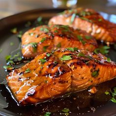 two pieces of salmon on a black plate