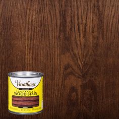 a can of wood stain sitting on top of a wooden floor next to a wall