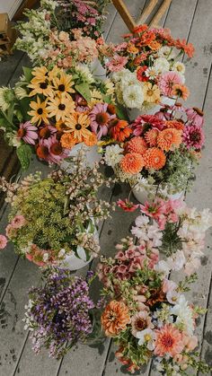 many different types of flowers on a wooden floor