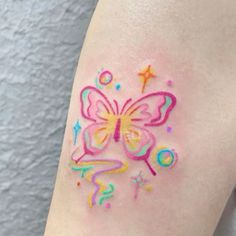 a colorful butterfly tattoo on the left thigh and right leg, with stars around it