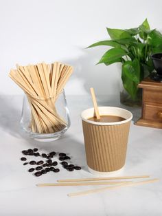 a cup of coffee and some sticks on a table