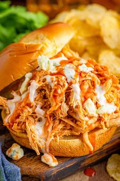 slow cooker buffalo chicken sandwiches on a cutting board with text overlay that reads slow cooker buffalo chicken sandwiches