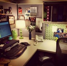 an office desk with a computer, phone and lamp