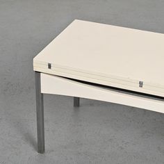 a white table sitting on top of a gray floor