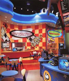 the inside of a fast food restaurant with blue and red checkered walls, tables, and chairs