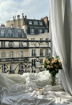 a vase filled with flowers sitting on top of a window sill next to a bed