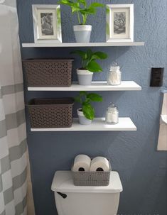 the bathroom is decorated in blue and white with pictures on the wall above the toilet