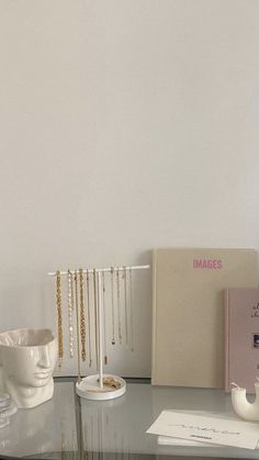 a glass table with jewelry on it and a book in front of the top shelf