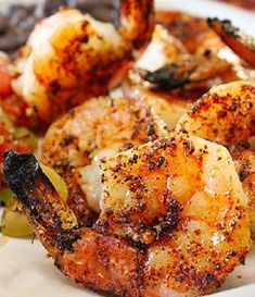 a white plate topped with shrimp and vegetables