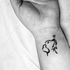 a woman's wrist with a small tattoo design on the left side of her arm