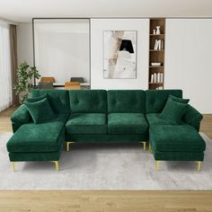 a living room with a large green sectional couch and white rug on the wooden floor