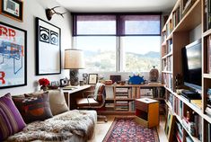 a living room filled with lots of furniture and bookshelves next to a window